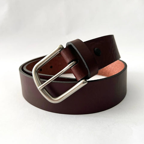The Rogue Industries Baxter Leather Belt, 1.5 wide, crafted from premium cowhide leather with a smooth finish and black edging, is coiled on a white background and features a silver metal buckle.