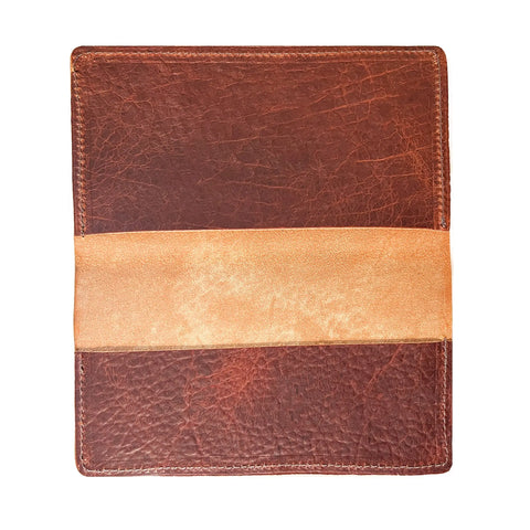The Rogue Industries Leather Checkbook Cover features a square, brown American Bison leather design with a horizontal tan band, visible texture, and natural creases.