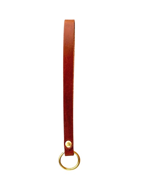 The Homestead Brand Standard Wristlet No. 1604 is a brown full grain leather keychain strap, handmade in the USA, with a brass rivet and round brass key ring, shown against a plain black background.