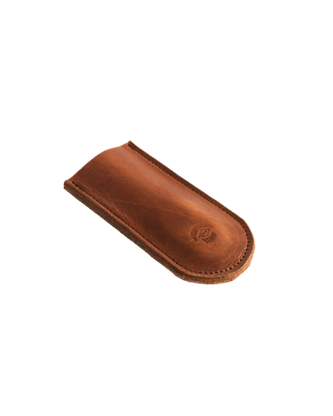The Homestead Brand Skillet Handle Sleeve No. 2002 is a brown full grain leather cover with rounded edges and visible stitching, ideal for small items like a pen or glasses, shown on a white background.