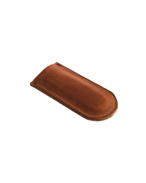 The Homestead Brand Skillet Handle Sleeve No. 2002, a brown leather case with visible stitching, rests on a white background—crafted with quality similar to premium leather pen or eyeglass cases.