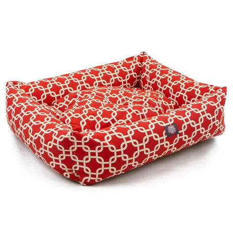 The Majestic Pet Links Luxe Bagel Bed is a red dog bed with raised sides and a white chain pattern, cushioned base, and front label. Its machine washable, offering both comfort and easy care for your pet.
