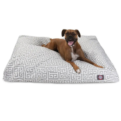 A brown and white dog relaxes with its mouth open on the Majestic Pet Towers Rectangle Dog Bed, featuring a gray and white geometric pattern, washable cover, and premium polyester fill for comfort.