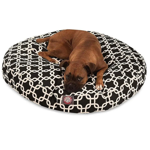 A brown dog relaxes on the Majestic Pet Links Round Dog Bed, featuring a black-and-white pattern and a removable, machine-washable cover for easy cleaning.