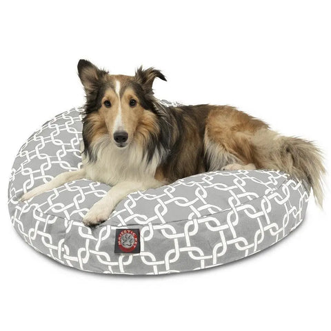 A Collie relaxes on the Majestic Pet Links Round Dog Bed, featuring a gray cover with a white geometric pattern and a red-black patch. The removable cover keeps your pet cozy and allows for easy cleaning.