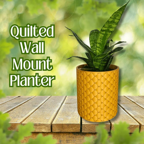 A green snake plant in a yellow Chatelet Manufacturing Quilted Design Wall Planter with hidden drip tray and mounting kit sits on wood, with Quilted Design Wall Planter text and a blurred leafy indoor gardening background.