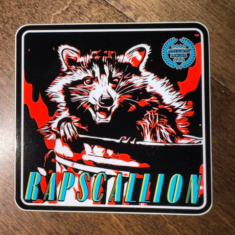 The American Lictor Sticker: Raccoon - Rapscallion features a cute raccoon illustration with an open mouth on a red and black background, bold blue and yellow RAPSCALLION text below, plus a blue badge in the top right.