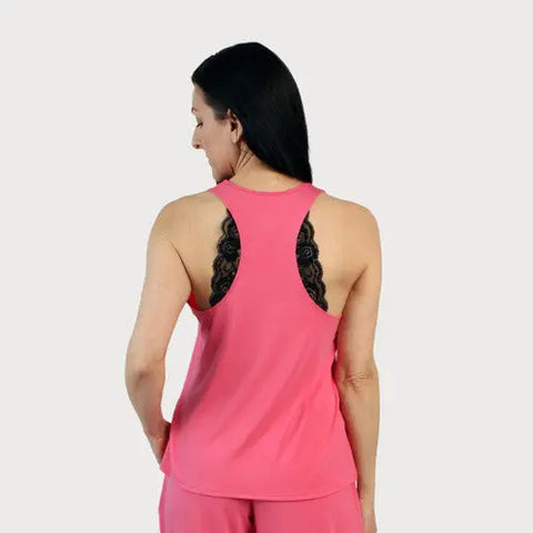 A woman with long dark hair, seen from the back, wears the Goodnighties Lace Accent Racerback Tank Top. Black lace details of this sleepwear for women are visible through the tanks design.