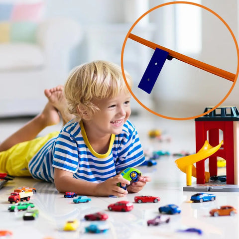 A young child plays with toy cars on the floor, surrounded by Hot Wheels tracks using Chatelet Manufacturing Racetrack Wall Connectors—screw-in or adhesive versions to create epic racecourses. Close-up shows an orange track for added excitement.