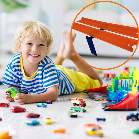 A smiling child lies on the floor, surrounded by Hot Wheels tracks using Chatelet Manufacturings Racetrack Wall Connectors. An inset shows orange track pieces with blue supports for epic racing fun. Made in the USA, adhesive or screw-in versions available.