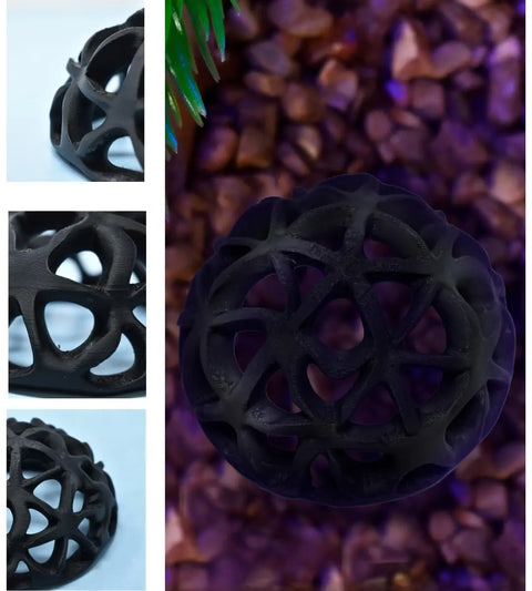 The Chatelet REEFSHAPE Dome, by Chatelet Manufacturing, is a black geometric aquarium hideout with interconnected curves. Shown on brown pebbles and in close-ups, its intricate open design creates a unique reef decor for fish or shrimp tanks. Made in USA.