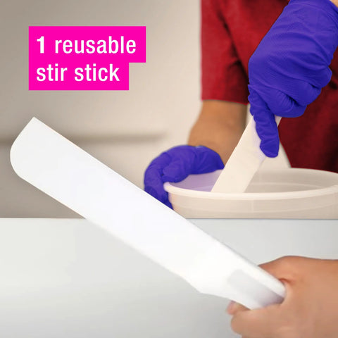 A person with purple gloves uses the ArtResin reusable stir stick from the ArtResin Accessory Kit to mix resin in a white container. In the foreground, another hand holds the same stir stick. Text: 1 reusable stir stick by ArtResin.
