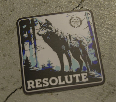The American Lictor “Sticker: Wolf - Resolute” features a black wolf in a blue-accented forest on a square sticker with a textured gray background, bold “RESOLUTE” text below, and a circular emblem in the upper right corner.