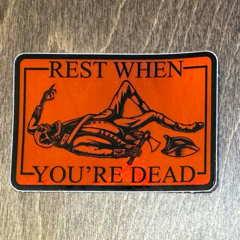 The American Lictor Rest When Dead sticker is orange, 3x2, and features a black skeleton in vintage clothes with a shovel and the phrase Rest When Youre Dead above and below the image.