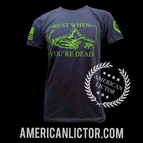 The American Lictor T-Shirt: Rest When Youre Dead features neon green text, a skeleton graphic, and American flag sleeve details—ideal motivational wear for an active lifestyle. AMERICAN LICTOR logo, website, and size guide appear below the shirt.