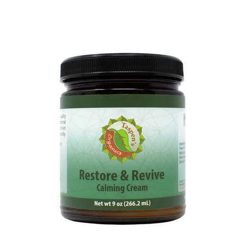 A 9 oz jar of Taspens Organics Restore & Revive Calming Cream for sensitive skin features a green and white label with the brand logo and product name, in a dark amber American-made container with a black lid.