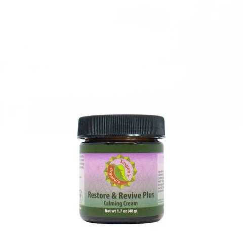 A small jar of Taspens Organics Restore & Revive Calming Cream PLUS, enriched with organic essential oils, features a black lid and a green and lavender label, set against a plain white background.