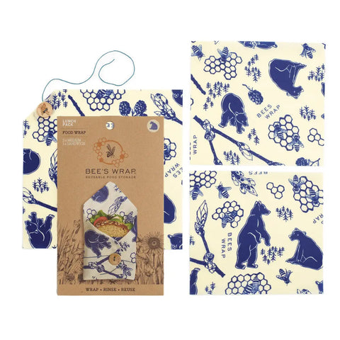 Bees Wrap The Lunch Pack features reusable wraps in various sizes with blue bear, honeycomb, and bee patterns on a cream background. Packaging displays branding and an illustration of food wrapped in these washable wraps.
