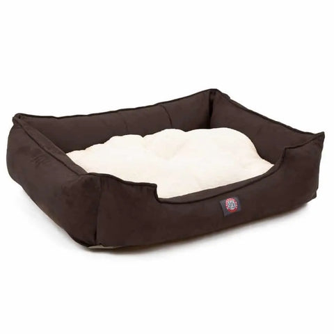 The Majestic Pet Suede Contemporary Lounge Bed features high brown sides, a soft cream cushion center, a low front entry for easy access, and a small logo on the front.