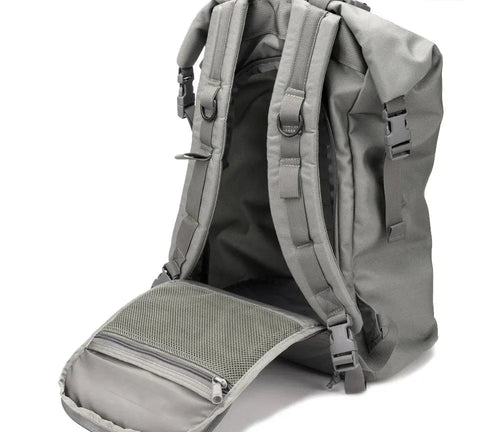 The MIS Roll Up Backpack - Foliage stands upright with its back panel unzipped and folded down to reveal a mesh zip pocket inside. This water-resistant Cordura Nylon bag has padded shoulder straps and plastic buckles.