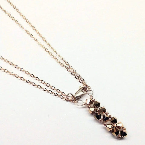 The Super Sparkly Crystal Rock Candy Beaded Rose Gold Crystal Bar Necklace by Alexa Martha Designs features a cluster of faceted crystal beads as a pendant, displayed against a plain white background.