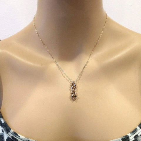 A mannequin wears the Super Sparkly Crystal Rock Candy Beaded Rose Gold Crystal Bar Necklace by Alexa Martha Designs, featuring sparkling crystals. The mannequin is dressed in a patterned strapless top.