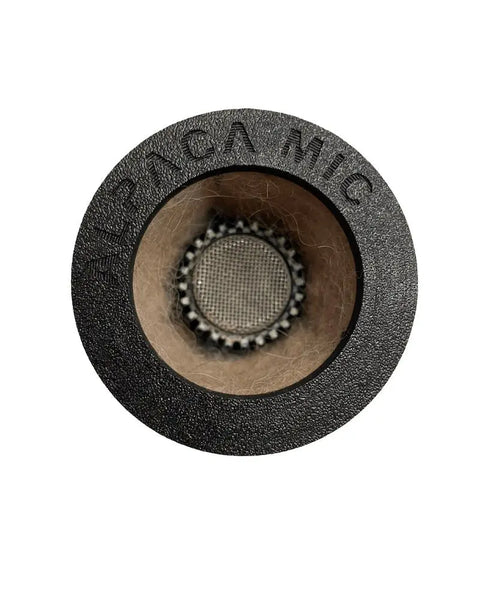 Close-up of the Alpaca Mic Alpaca 57: a round, black microphone accessory with light brown alpaca felt around its mesh-covered opening, designed for optimal isolation—compatible with microphones like the Shure SM57.
