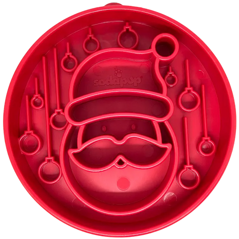 The SodaPup Santa Design EBowl is a red silicone slow feeder bowl for dogs, shaped like Santa’s face with raised details and enrichment patterns to promote healthy eating.