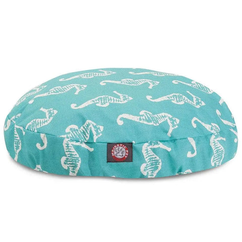 The Majestic Pet Sea Horse Round Dog Bed features a turquoise cover with white seahorses, a branded side tag, and a removable washable cover for easy cleaning.