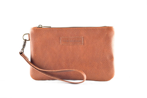 The Sebago Leather Clutch by Rogue Industries features brown leather, a zipper closure, and a detachable wristlet strap, shown against a white background.