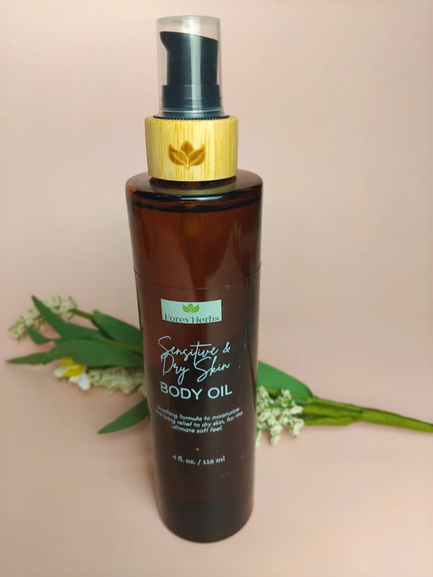 A brown pump bottle of Forev'Herbs Sensitive & Dry Skin Body Oil with a wooden cap stands against a light pink background, adorned with small white and green flowers—a natural moisturizer for sensitive, dry skin.