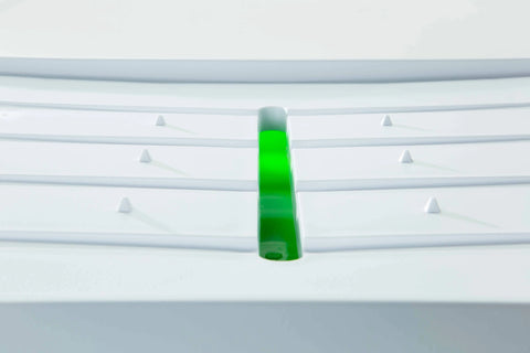 A close-up of Karving Kings Set of 2 Dripless Cutting Boards 2 in 1 System, showing a horizontal slit with a bright green translucent center, raised ridges, and small triangular bumps for efficient food prep.