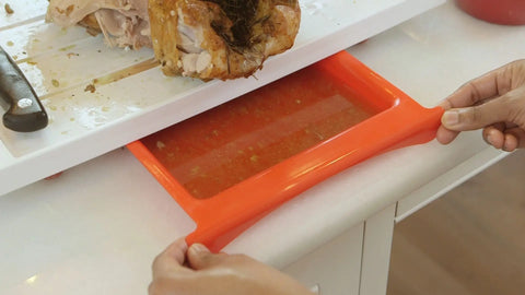 The Karving King Set of 2 Dripless Cutting Boards 2 in 1 System features a flexible red tray that collects flavorful meat juices beneath the board, creating a dripless, mess-free carving experience.