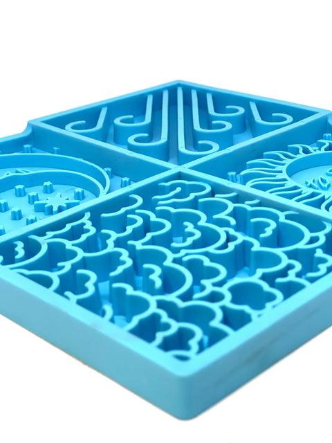 A close-up of the Sky Design EMat Enrichment Lick Mat by SodaPup, featuring four blue sections with distinct textured patterns and small pegs to help calm dogs and support their digestive health.