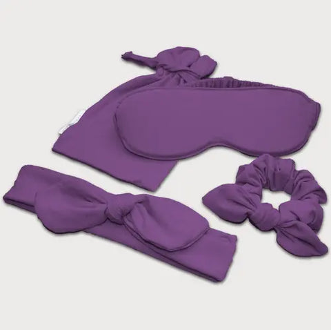 The Goodnighties Accessories Value Pack includes a purple eye mask, scrunchie, bow headband, and matching pouch—all soft and comfy. Perfect for pairing with your American-made sleepwear.