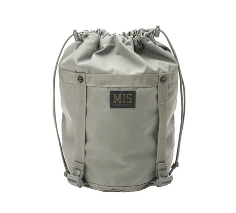 The MIS Compression Stuff Sack Small in foliage is made of durable, water-resistant fabric with side straps, sturdy stitching, a 9L capacity, and features a black MIS patch on the front.