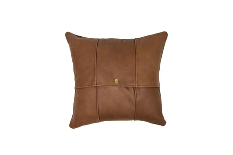 The Urban Southern Small Leather Pillow is square and brown, crafted from full-grain leather with visible stitching and a central button, shown against a white background.