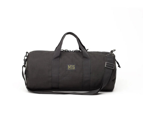 The MIS Training Drum Bag Small - Black is made from 1000 denier Dupont Cordura Nylon, featuring two short handles, a long adjustable shoulder strap, an MIS logo patch on the front, and a heavy-duty YKK zipper. Set against a white background.