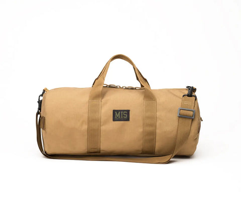 The MIS Training Drum Bag Small in Coyote Brown is a water-resistant Cordura Nylon duffel with two handles, an adjustable shoulder strap, and an MIS patch, made in the USA and shown on a white background.