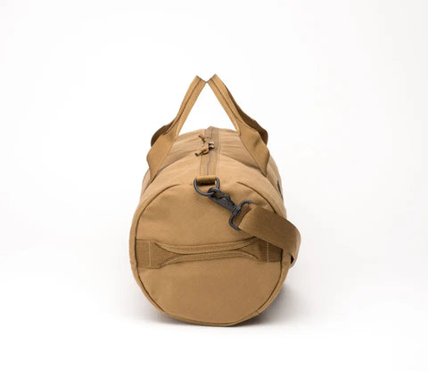 The MIS Training Drum Bag Small in Coyote Brown is a cylindrical, water-resistant duffel made in the USA from Cordura Nylon, featuring a zippered top, matching handles, and an adjustable shoulder strap. Shown standing upright on a white background.