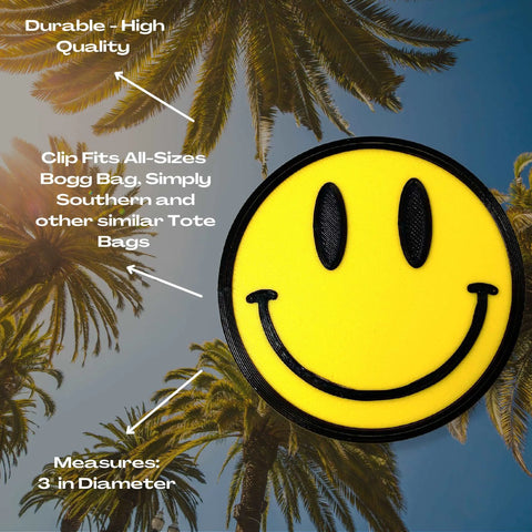 The FRESHe BOGLETS Smiley Emoji Charm by Chatelet Manufacturing features a durable yellow smiley face with a black outline, compatible with Bogg Bags, Simply Southern, and other totes—perfect as a fun and stylish bag accessory.