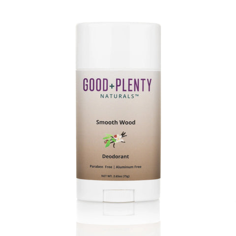 A white stick of Good + Plenty Naturals™ Smooth Wood Aluminum-Free Natural Deodorant, labeled as paraben free and aluminum free, with floral and wood illustrations on the front.
