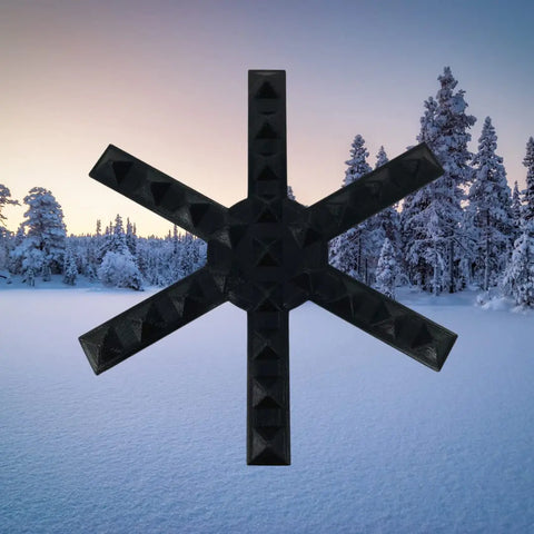 The Chatelet Manufacturing Snowboard Stomp Pad features a black, geometric snowflake spike pattern for enhanced grip, shown centered over snowy trees and a pastel sunset sky.