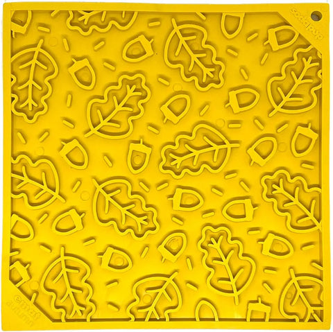 The SodaPup Autumn Design EMat Enrichment Lick Mat features a yellow surface with raised oak leaves, acorns, and dashes—ideal for canine enrichment and food enrichment activities.