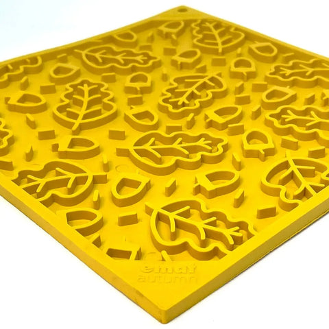 The SodaPup Autumn Design EMat Enrichment Lick Mat is a yellow silicone mat with raised autumn leaf shapes and small geometric pieces, perfect for dog enrichment. Cricut autumn is embossed in one corner.