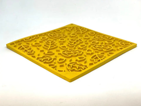 The SodaPup Autumn Design EMat Enrichment Lick Mat, shown in yellow with raised leaf patterns, is perfect for canine enrichment and promoting dog health.