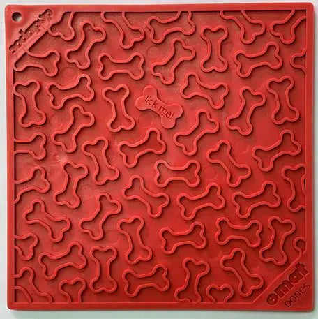 The Bones Design EMat Enrichment Lick Mat by SodaPup is a red silicone mat with a raised bones pattern, lick me in the center, and encourages licking for dogs enrichment.