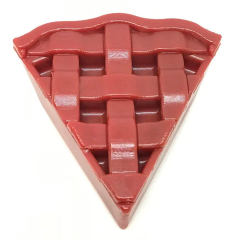 The SodaPup Cherry Pie EChew Ultra Durable Nylon Dog Chew Toy and Treat Holder is a glossy, triangular red toy with textured pie details, designed for power chewers and made to look like a slice of lattice-top cherry pie.