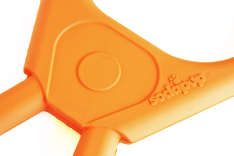 Close-up of the orange Pop Top Rubber Tug Toy for Interactive Play by SodaPup, featuring a Y-shape, durable rubber construction, smooth texture, and a circular pattern near the top center. The SodaPup brand name is embossed on the surface.