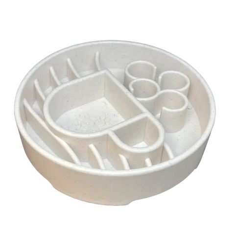 The SodaPup Java Design EBowl Enrichment Slow Feeder Bowl for Dogs is a round, white plastic bowl with maze-like barriers and paw-shaped compartments to slow your dogs eating and provide enrichment.